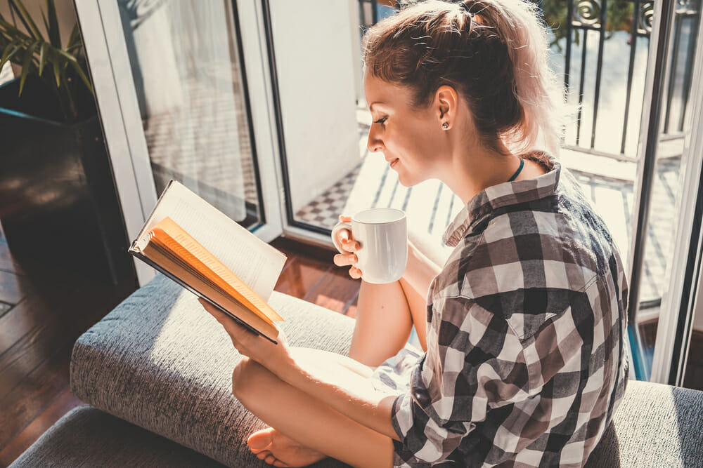 woman reading a book with a cup of coffee