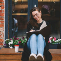Woman writing in front of flowers