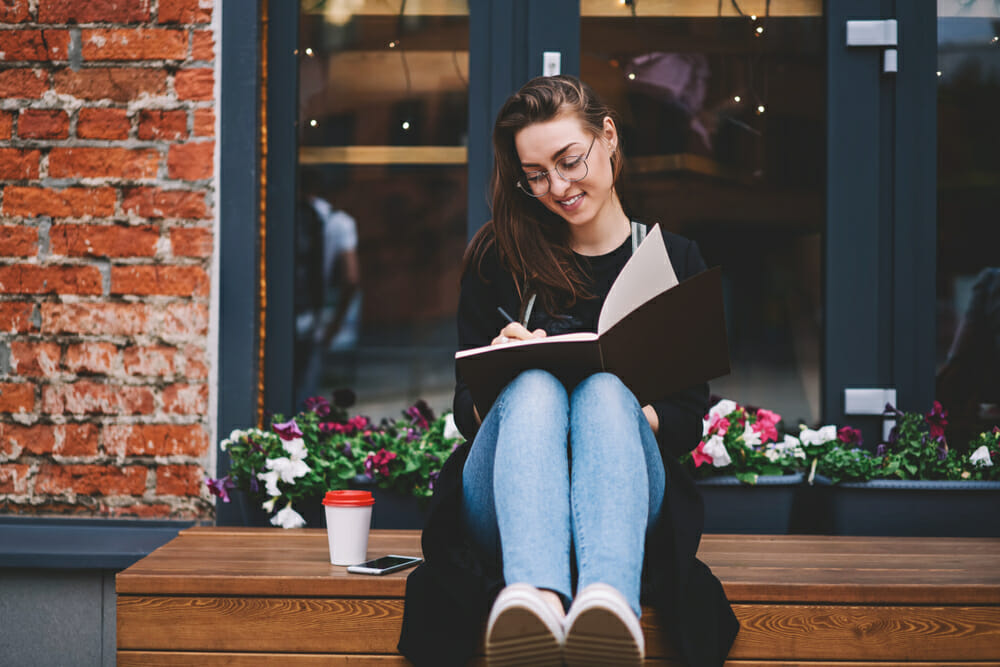 Woman writing in front of flowers