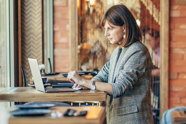 Woman sitting with her laptop at a cafe