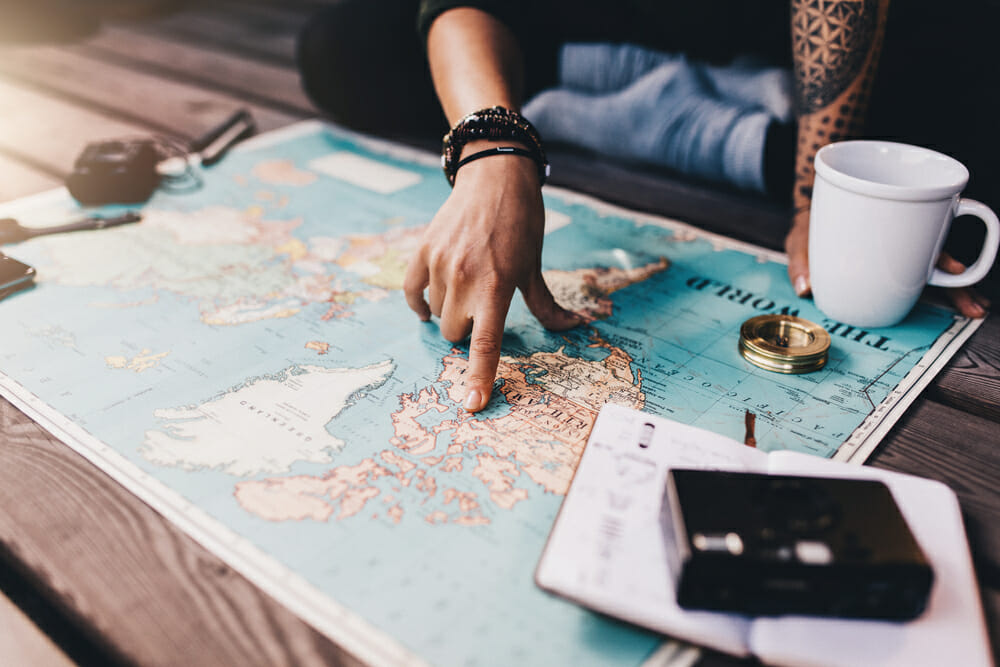 Person pointing at a map of the world