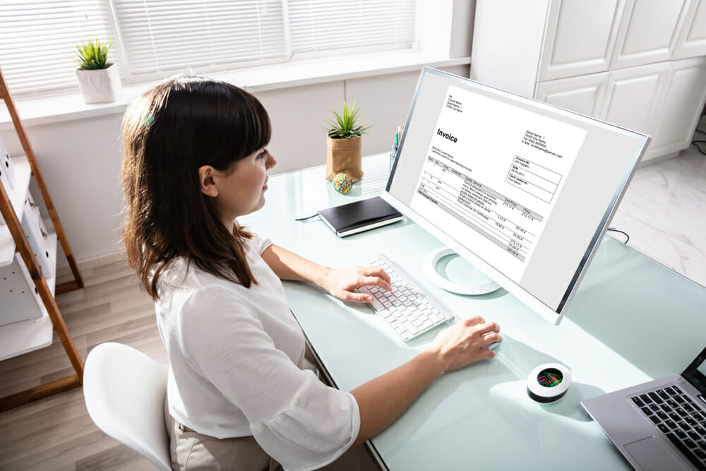 Woman sitting at a desk working on an invoice