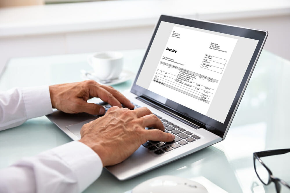 Man typing an invoice on his laptop