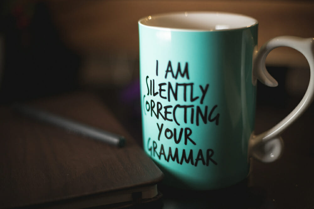 Blue mug that says "I am silently correcting your grammar"