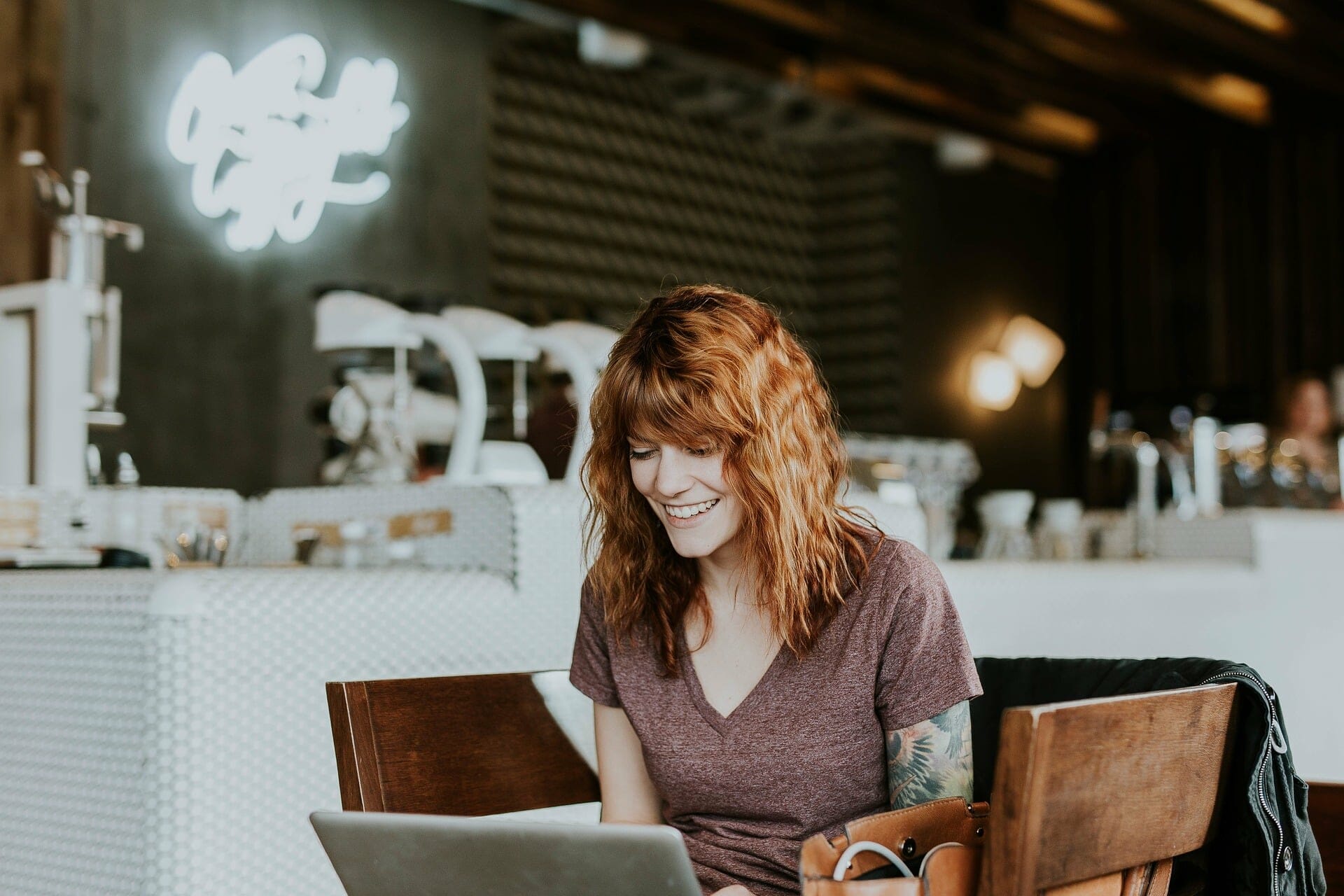 woman typing on a laptop at a cafe