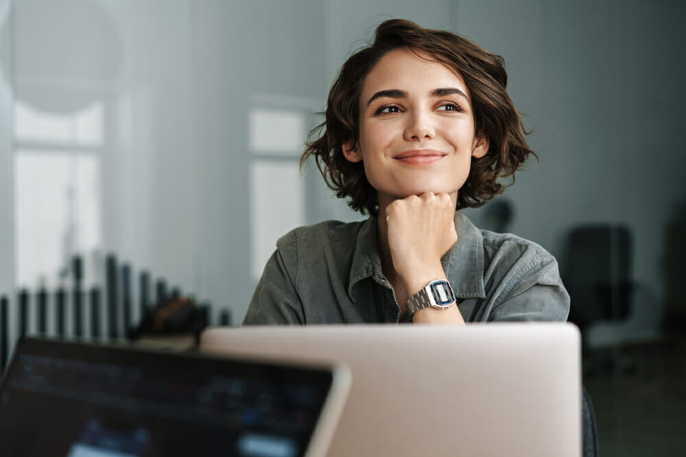 Woman sitting behind her laptop smiling