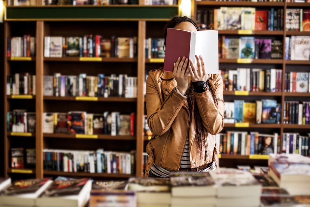 Woman holding up a book at a bookstore
