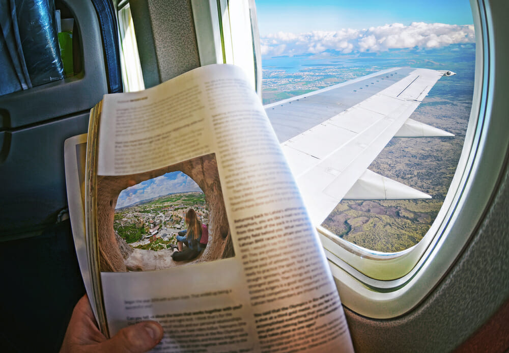 magazine story in front of an airplane window