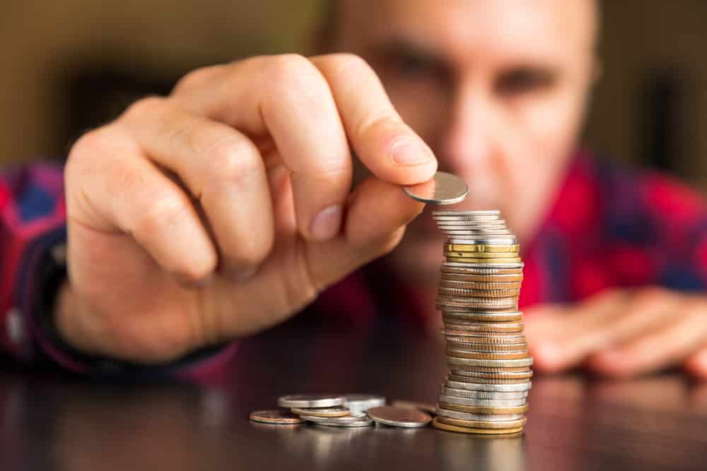 Man stacking coins on a table