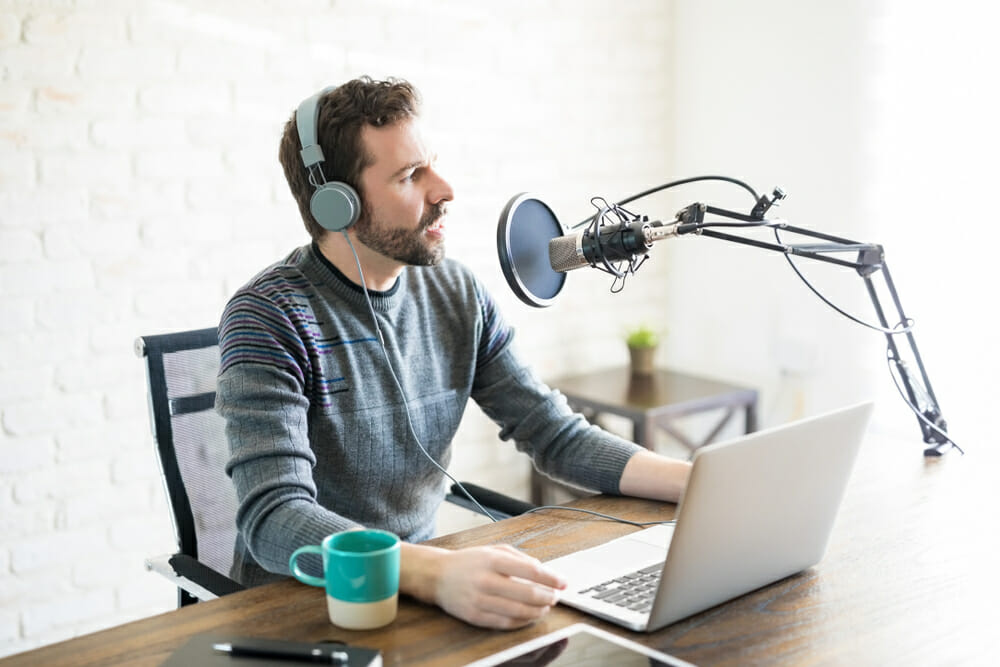 Man sitting at a table recording a podcast