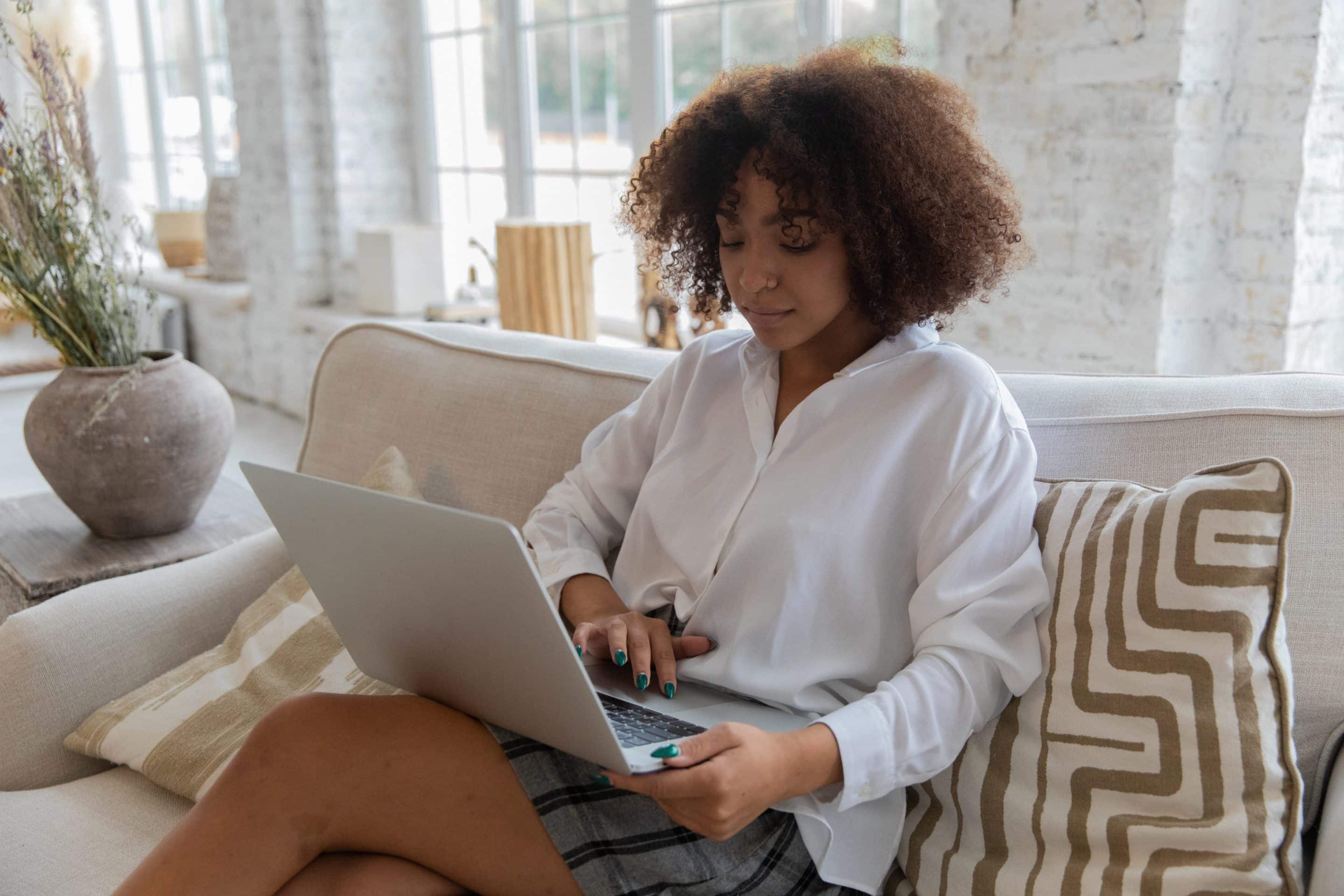 Woman sitting on a couch with her laptop.