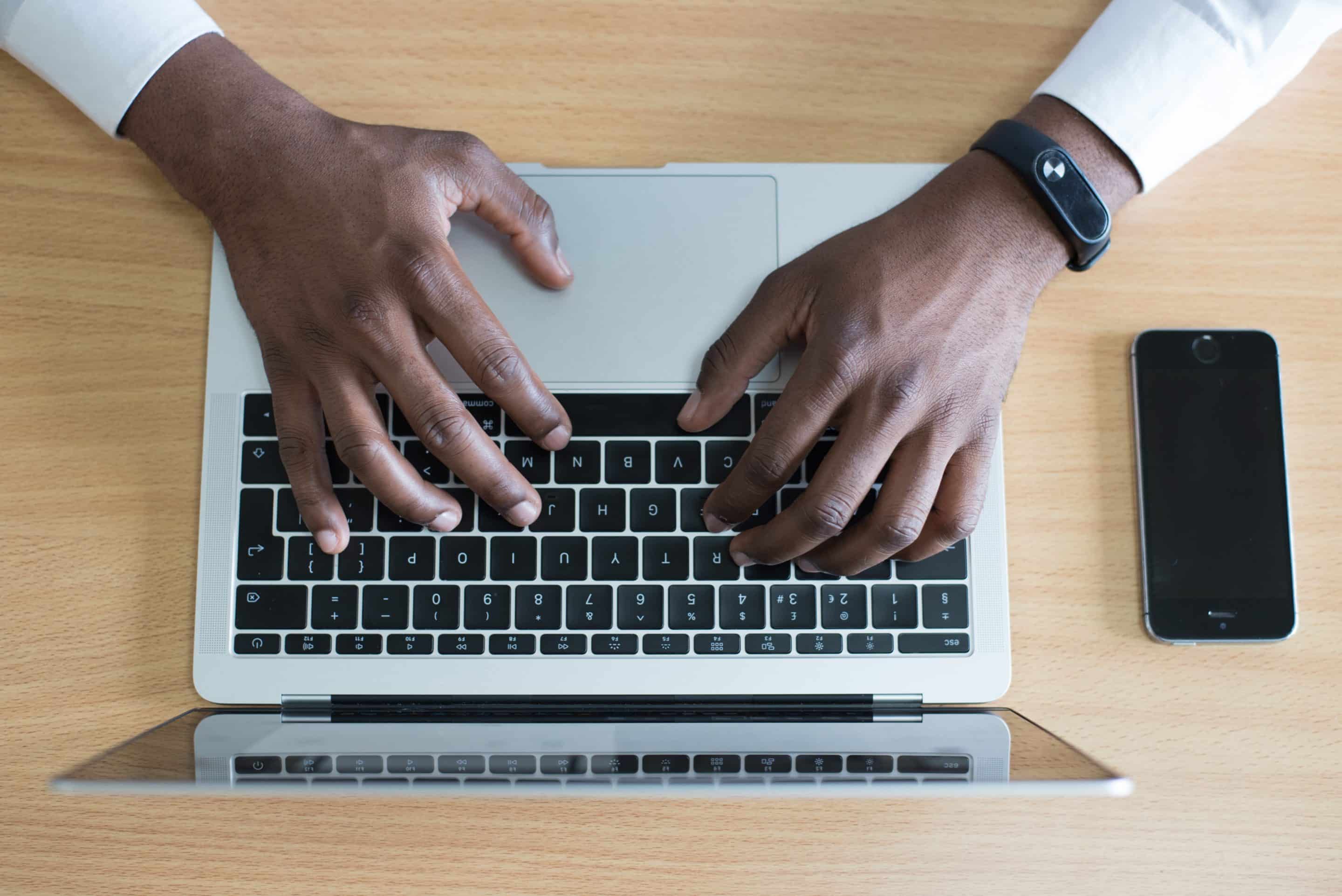 Overhead shot of a man's hands on a keyboard typing