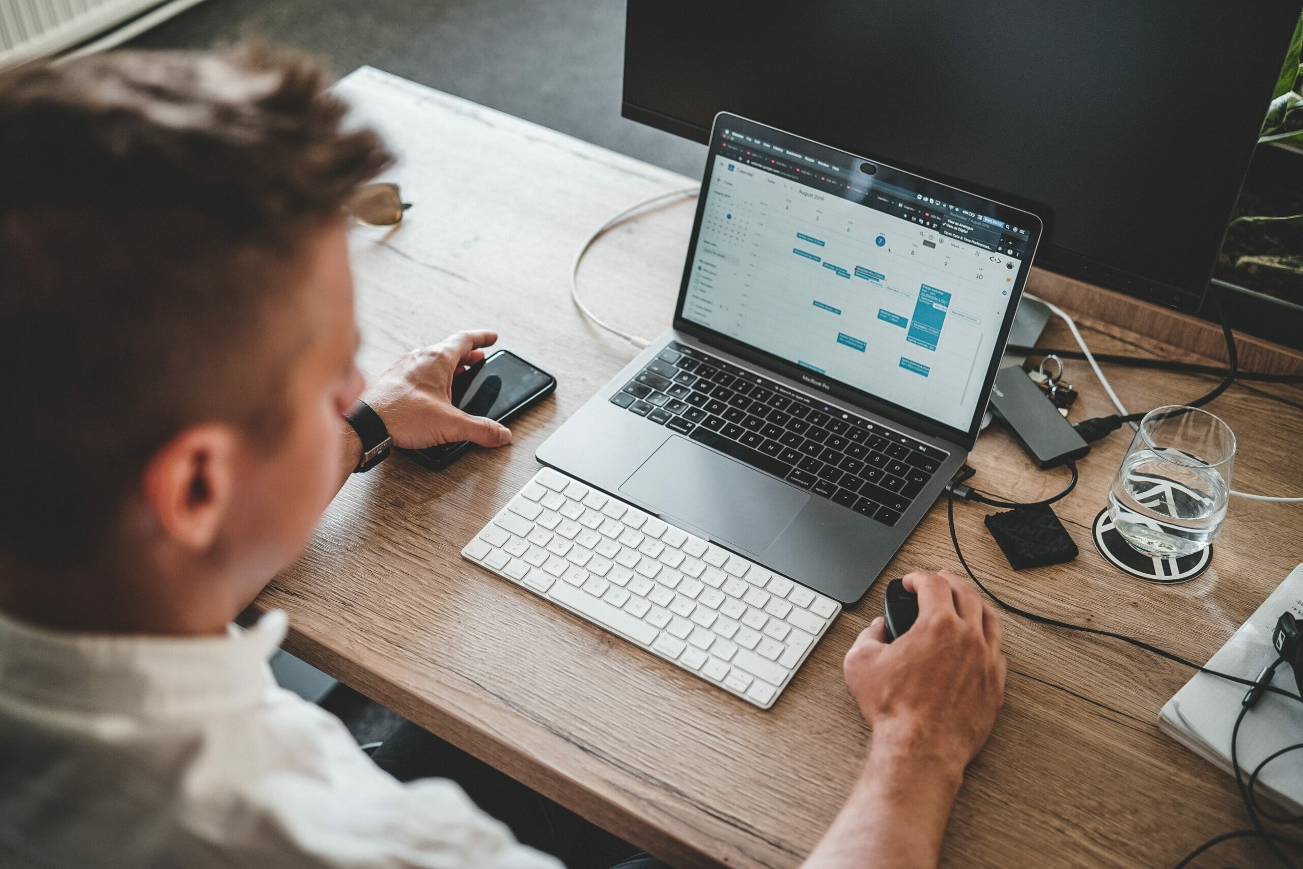 Man sitting in front of his laptop looking at his Google Calendar