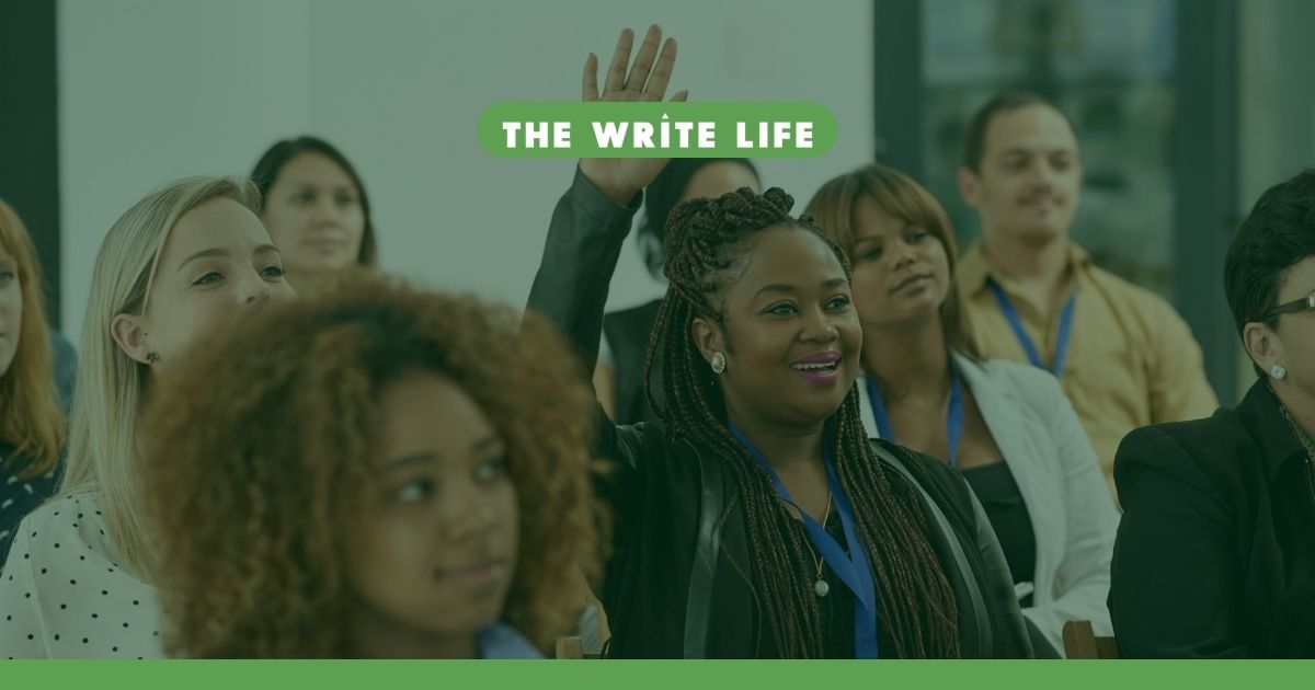 A stock image of a group of people wearing lanyards and sitting in a banquet room to illustrate writers conferences in this roundup article of in-person and online options.